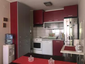 une cuisine avec des armoires rouges et des appareils blancs dans l'établissement Apartman AS, à Belgrade