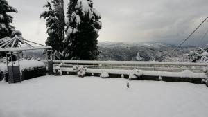 a snow covered fence with a view of the mountains at Pacithea Villas in Miléai