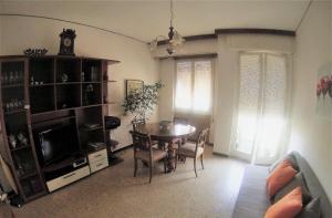 sala de estar con mesa de comedor y TV en Appartamento vista mare, en Tellaro