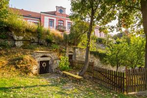 ein altes Gebäude mit einem Tor und einem Zaun in der Unterkunft Zámek Lobeč in Lobeč