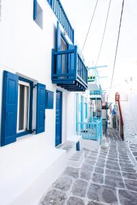 a blue door and stairs on a white building at Anamnisi Mykonos in Mýkonos City