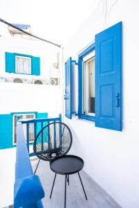 a room with a blue door and a table and chair at Anamnisi Mykonos in Mikonos