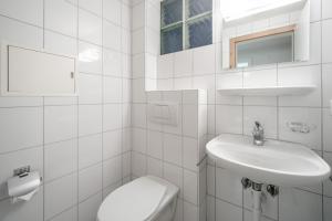 een witte badkamer met een toilet en een wastafel bij Casa Casura in Falera