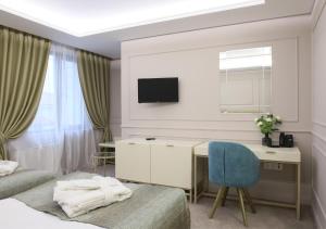 ein Hotelzimmer mit Schreibtisch und Bett mit einem blauen Stuhl in der Unterkunft Monte Vedetta in Sliven