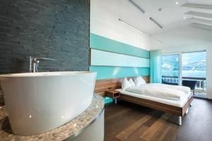 ein Badezimmer mit einer Badewanne neben einem Bett in der Unterkunft Superior Hotel Nidwaldnerhof in Beckenried