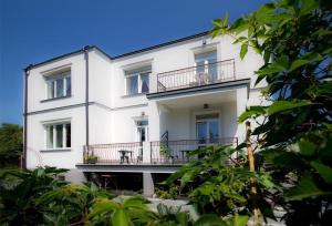 Casa blanca con balcón y mesa. en Willa Halina, en Sandomierz