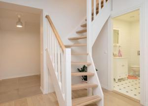 a white staircase in a home with a bathroom at Modern quiet 2 bedroom apartment near City center in Pärnu +22 photos