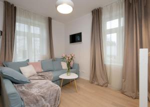a living room with a blue couch and a table at Modern quiet 2 bedroom apartment near City center in Pärnu