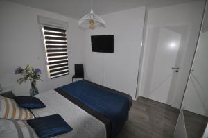 1 dormitorio con cama con sábanas azules y ventana en Dervenn Mor, en Sarzeau