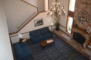 a living room with a blue couch and a fireplace at Super 8 by Wyndham Greenfield in Greenfield