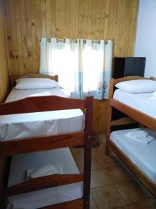 a room with three bunk beds and a window at Cabañas Nativa in Montecarlo