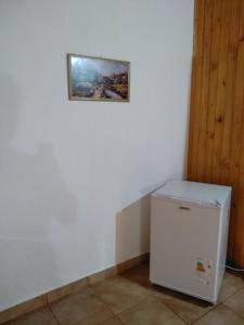 una nevera en una habitación con una foto en la pared en Cabañas Nativa en Montecarlo