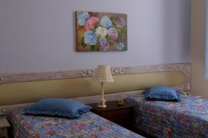 2 camas con almohadas azules en una habitación en POUSADA CASARÃO NORONHA KAUAGE, en Cristina