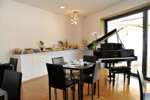 uma sala de jantar com uma mesa e um piano em Hotel Del Conte em Fondi