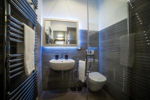 een badkamer met een wastafel, een toilet en een spiegel bij Central Florence in Florence