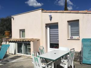 una mesa y sillas frente a una casa en L'Eden, en Ansouis