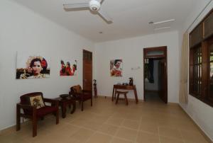 a living room with chairs and paintings on the walls at Dasa Wana Resort in Candidasa