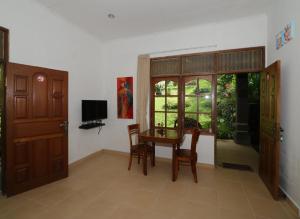 a dining room with a table and chairs and a window at Dasa Wana Resort in Candidasa