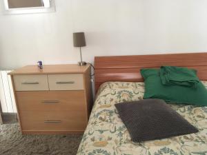 1 dormitorio con cama con almohada verde y vestidor en L'Eden, en Ansouis