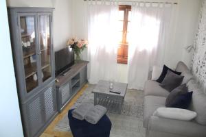 a living room with a couch and a tv at Apartamento Frida Faro Park in Playa Blanca