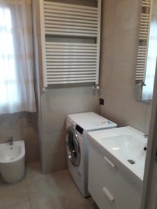 ein Badezimmer mit Waschmaschine und Waschbecken in der Unterkunft Appartamento al mare Lorella in Sottomarina