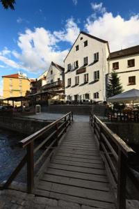 un puente de madera sobre una masa de agua con edificios en Hotel Edward Kelly, en Český Krumlov