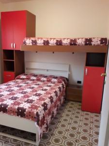 a bedroom with a bunk bed and red cabinets at Appartamento al mare Lorella in Sottomarina