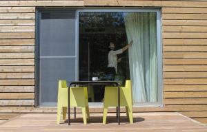 a person standing in a window with a table and chairs at Furnas Lake Forest Living in Furnas