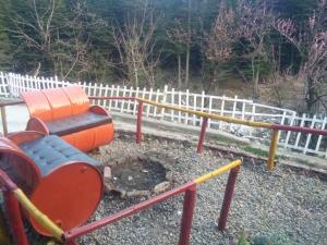 a playground with a slide in front of a fence at Homestay Near Club House in Manāli