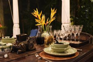 a wooden table with plates and glasses on it at Orchard House Galle in Galle