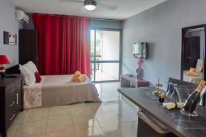una camera con letto e tenda rossa di Appartements Cayenne Standing a Cayenne