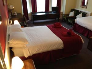 a hotel room with two beds and a piano at Abbey Lodge Hotel in London