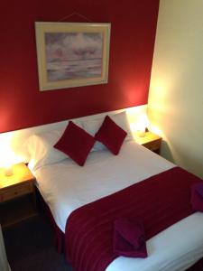 a hotel room with a bed with red walls at Abbey Lodge Hotel in London