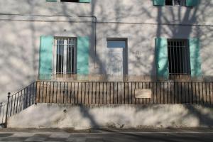 a fence in front of a building with windows at Au bonheur de LILI in Fontaine-de-Vaucluse +1 photo