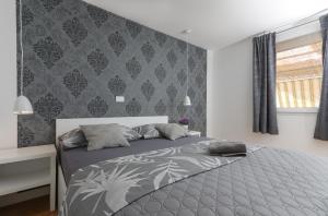 a bedroom with a bed with a gray comforter at Secluded Seaside Holiday Home in Milna +52 photos