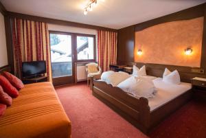 a hotel room with two beds and a television at Alpen Apartments Austria in Berwang