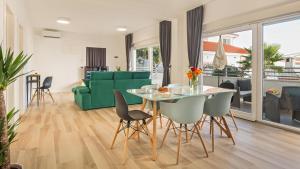 a living room with a table and a green couch at Sun & Salt Apartments in Bibinje