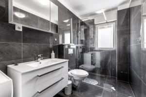 a black and white bathroom with a toilet and a sink at Apartment Suzana in Stobreč +15 photos