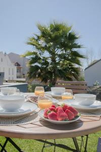 a table with plates of food and fruit on it at Liiiving In Porto | Downtown Luxury Apartments in Porto