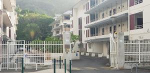 a white gate in front of a building at T1 tout confort in Saint-Denis