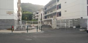 parking z białymi ogrodzeniami przed budynkami w obiekcie T1 tout confort w mieście Saint-Denis