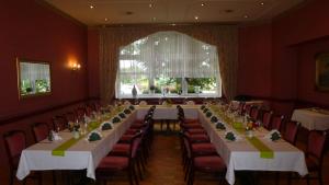 a long table in a room with red walls at Hotel Krone in Arnstadt