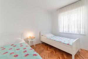 a bedroom with two beds and a window at Apartment Suzana in Stobreč