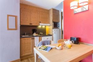 una cucina con un tavolo con una ciotola di frutta sopra di Résidence Pierre & Vacances L'Ours Blanc a LʼAlpe-dʼHuez