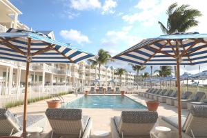 a swimming pool with chairs and umbrellas at Isla Bella Beach Resort & Spa - Florida Keys in Marathon