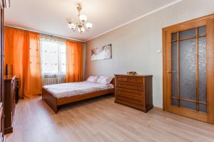 - une chambre avec un lit, une commode et une fenêtre dans l'établissement Apartments on Volgina, à Moscou