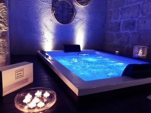 普利亞區格拉維納的住宿－Le Fornaci Imperial Lodge & Spa，客房内的带蜡烛的大型蓝色浴缸