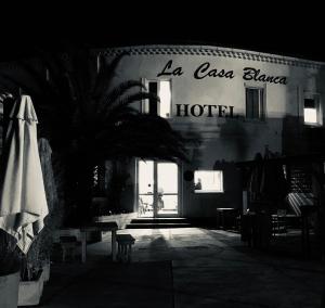 a building with a hotel sign and a palm tree in the dark at Hotel La Casa , Le Barcarès in Le Barcarès +72 photos