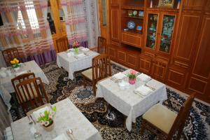 restauracja ze stołami i krzesłami z kwiatami w obiekcie Xum Don w Samarkandzie