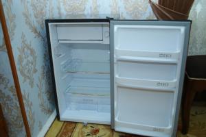 an empty refrigerator with its doors open in a room at Xum Don in Samarkand